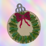 A round wooden Christmas ornament painted with a green wreath pattern, a red felt bow, and a silver hanging loop at the top, set against a pastel rainbow gradient background.
