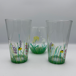 Three glass tumblers with floral designs on a white background