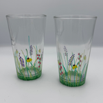 Two clear glasses with floral designs on a white background