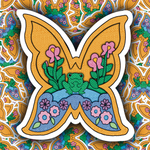 A butterfly-shaped sticker featuring a colorful retro illustration of a green frog, pink flowers, and blue waves on a patterned background.