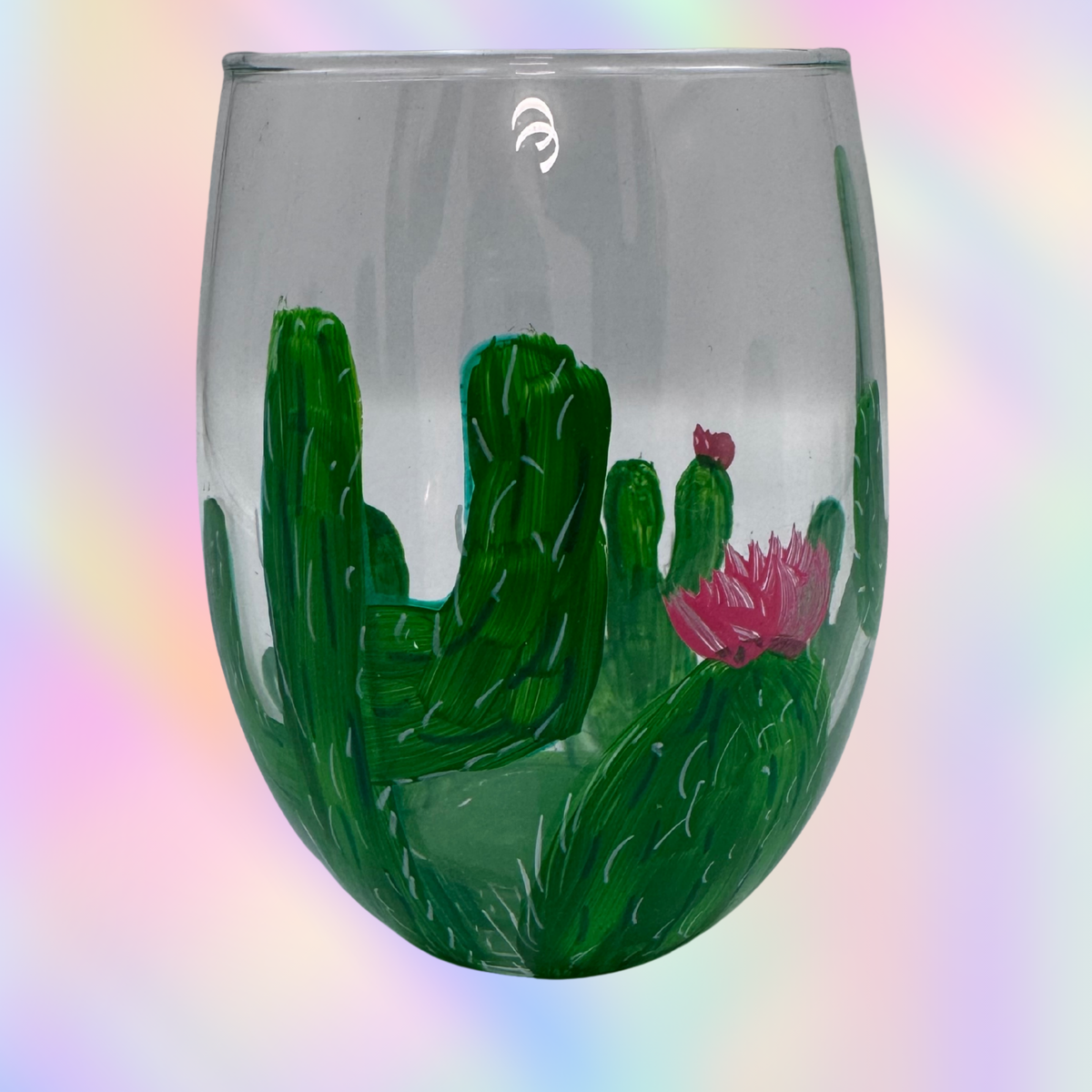 A clear stemless wine glass featuring a painted green cactus landscape with a pink flower, set against a soft pastel rainbow gradient background.