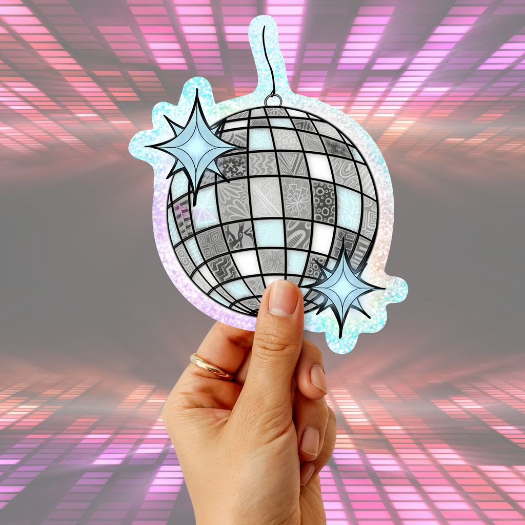 A hand holding a die-cut sticker or ornament shaped like a disco ball with two star accents, set against a pink and purple glowing grid background.