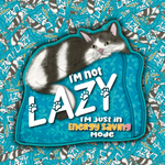 A die-cut sticker featuring a black and white cat lounging on a turquoise blue patterned cushion, with the text 'I'm not LAZY I'm just in Energy Saving Mode'. The sticker is displayed against a background of many identical stickers.