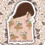 A die-cut sticker featuring an illustrated back with bandages and flowers, surrounded by a white border and the phrase 'Glow from what you go through' at the bottom. The sticker is shown against a background of repeated matching stickers.