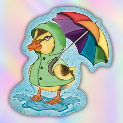 A die-cut sticker featuring an illustration of a cute yellow duckling wearing a green raincoat and holding a rainbow-colored umbrella, standing in a splash of water. The sticker is shown against a pastel rainbow gradient background.