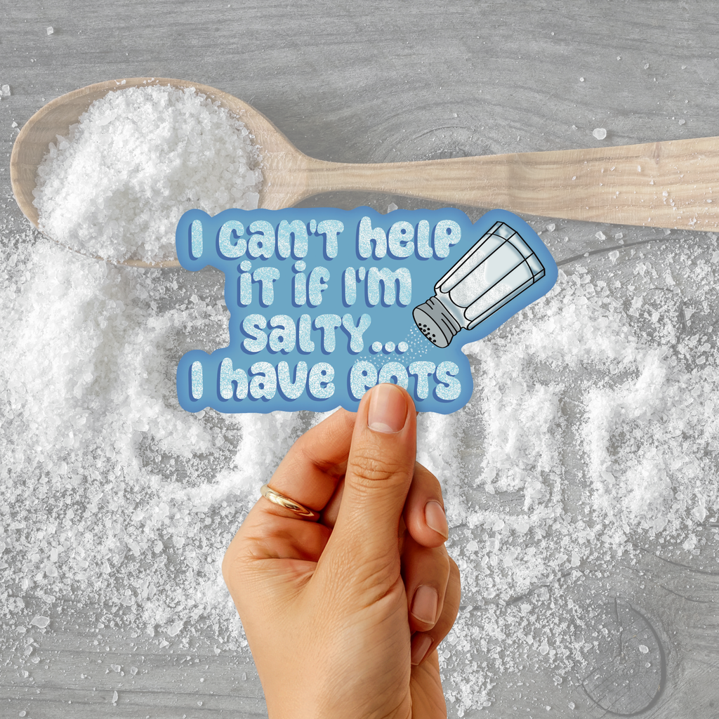 A hand holds a die-cut sticker with the text 'I can't help it if I'm salty.