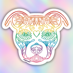 A die-cut vinyl sticker featuring a stylized dog head with ornate floral and decorative line art, filled with a rainbow gradient. The sticker is shown against a soft, iridescent pastel background.