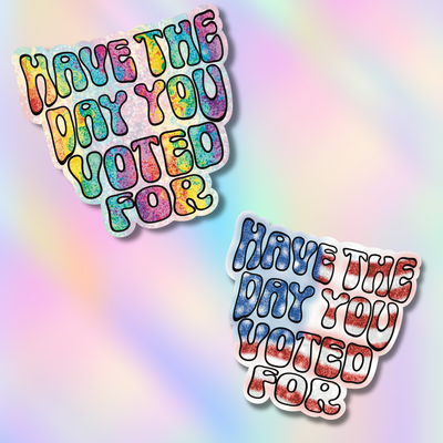 Two die-cut stickers with the phrase “HAVE THE DAY YOU VOTED FOR” in colorful bubble lettering, shown on a pastel rainbow gradient background. One sticker has a multicolor tie-dye effect, and the other has a blue-and-red distressed pattern.